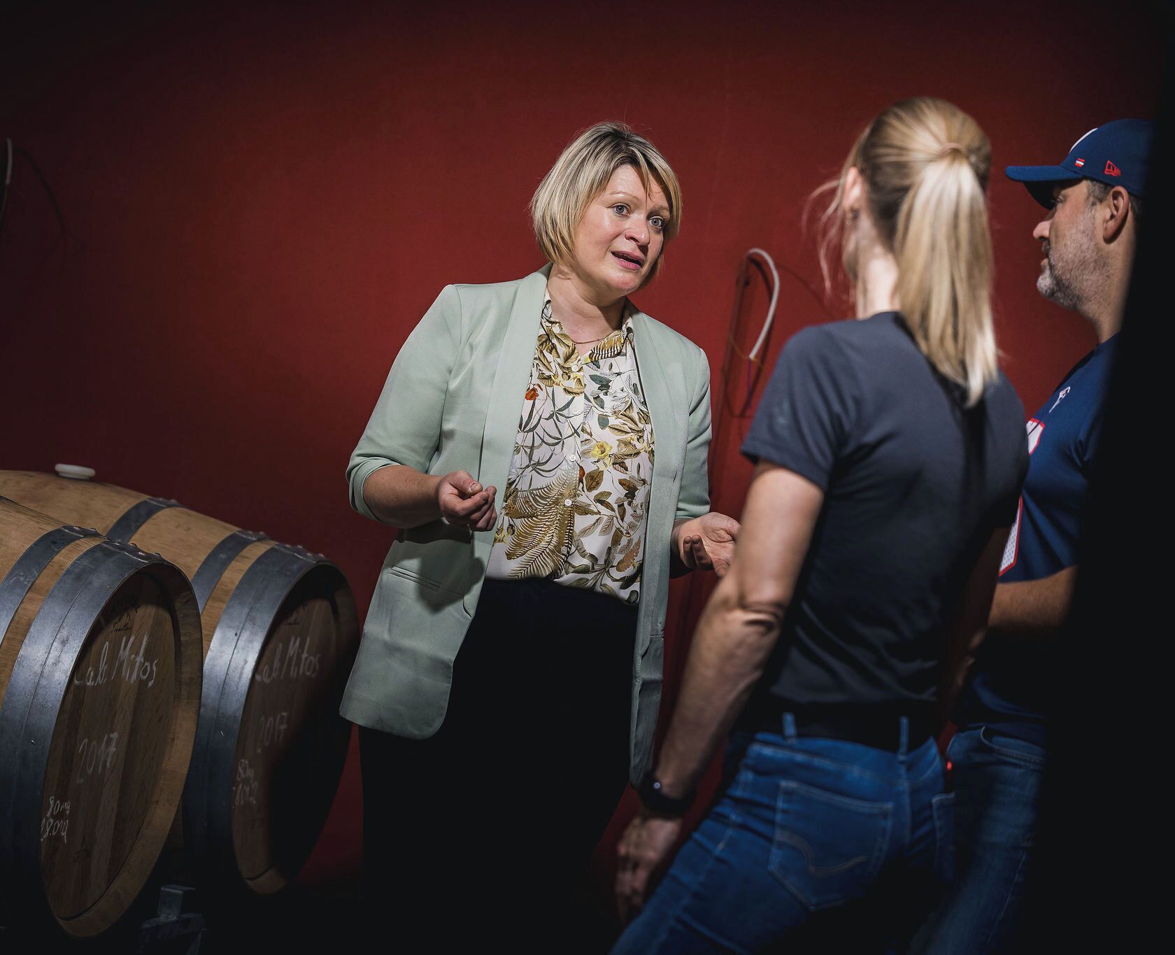 A group of people in a dimly lit room with wooden barrels.