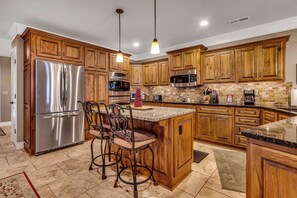 A kitchen with wooden cabinets, stainless steel appliances, and a marble countertop. - Lake View Retreat Near SDC with Free Tickets, Community Outdoor Pool & Upgraded Kitchen (Branson)