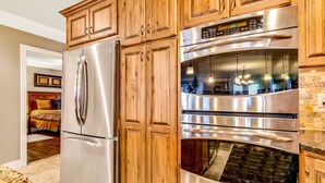 A kitchen with wooden cabinets, stainless steel appliances, and a double oven. - Lake View Retreat Near SDC with Free Tickets, Community Outdoor Pool & Upgraded Kitchen (Branson)