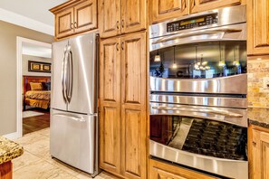 A kitchen with stainless steel appliances, wooden cabinets, and a granite countertop. - Lake View Retreat Near SDC with Free Tickets, Community Outdoor Pool & Upgraded Kitchen (Branson)