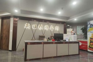 A reception desk with a modern design, a television, and a computer. - Four Seasons Qingteng Hotel (Outlet Airport) (Ningbo)
