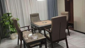 A hotel room with a dining table and chairs, a potted plant, and a wardrobe. - Four Seasons Qingteng Hotel (Outlet Airport) (Ningbo)
