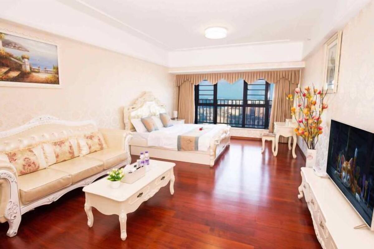 A spacious living room with a sofa, a bed, a coffee table, and a TV.