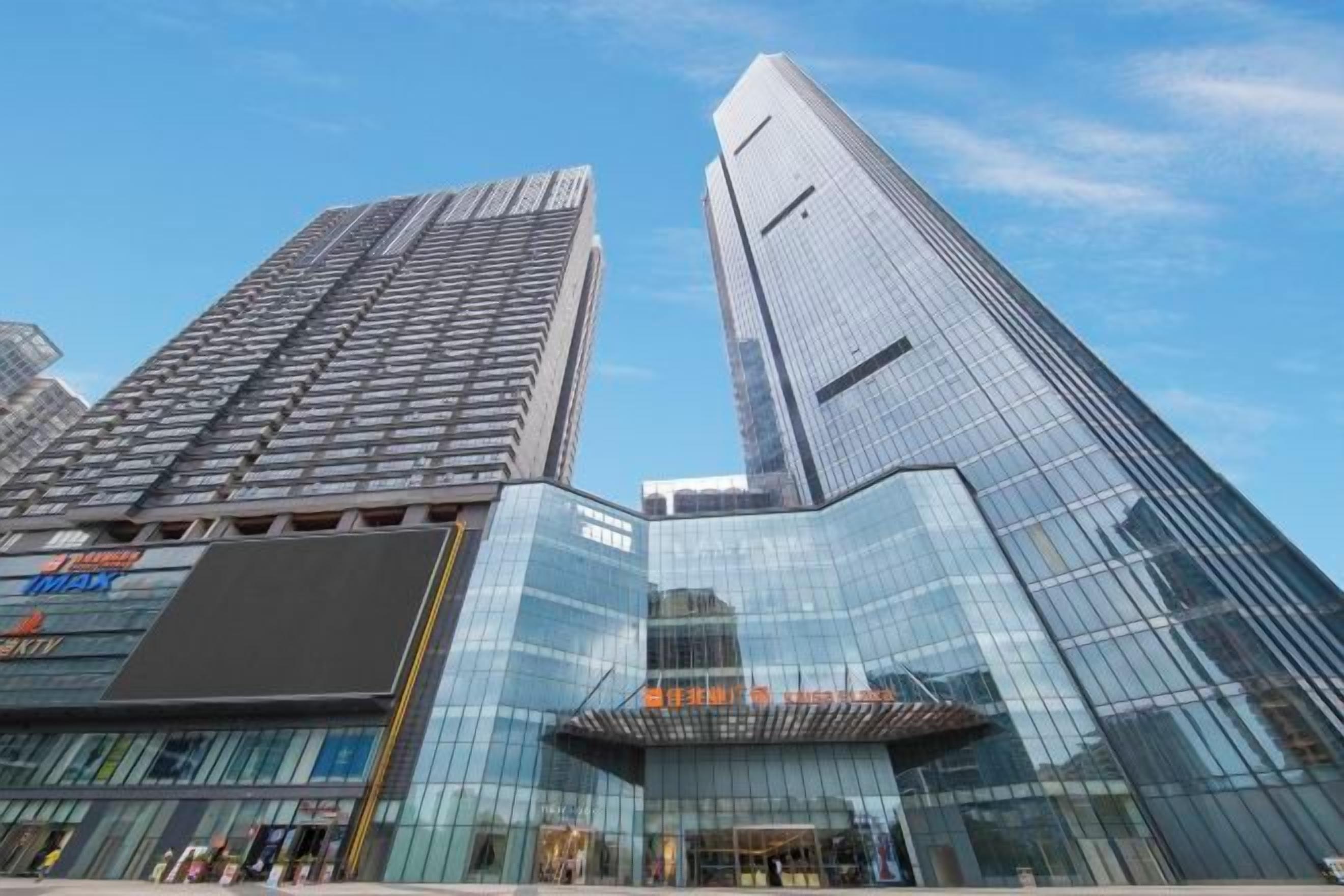 A modern building with a glass facade and a prominent vertical design element.