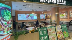 A restaurant with a green signboard, indoor seating, and digital menu displays. - Tianqin Mushang Hotel Apartment (Huizhou Kaisa Plaza) (Huizhou)