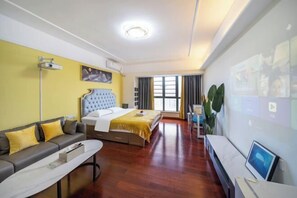 A hotel room with a bed, a sofa, a desk, and a large window. - Tianqin Mushang Hotel Apartment (Huizhou Kaisa Plaza) (Huizhou)