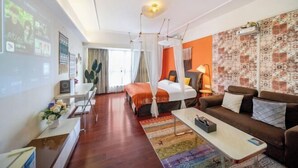 A hotel room with a bed, a sofa, a coffee table, a TV, and a desk with a computer. - Tianqin Mushang Hotel Apartment (Huizhou Kaisa Plaza) (Huizhou)
