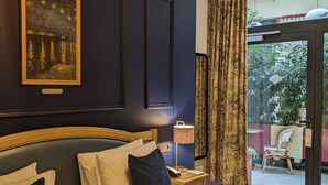 Un dormitorio con una cama grande, una mesita de noche, una lámpara y un cuadro en la pared.