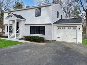 A two-story house with a garage, a front porch, and a driveway.