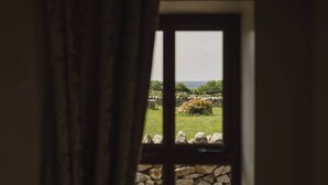 A window with a stone wall and a view of a grassy field. - The Rock, Creevy Cottages (Rossnowlagh)