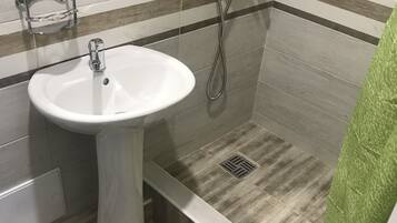 Habitación triple familiar | Baño | Regadera, amenidades de baño gratuitas, secadora de cabello, pantuflas