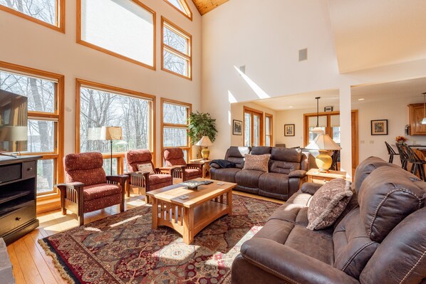 A spacious living room with a large window, a fireplace, and a cozy seating area.