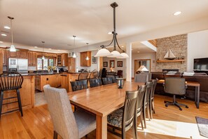 A spacious kitchen with wooden cabinets, a central island, and pendant lighting.