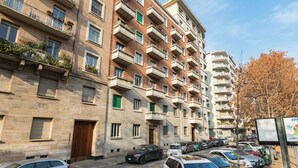 A multi-story residential building with balconies, a parking area, and a clear sky. - Elegante e raffinato in zona Crocetta by Wonderful Italy (Torino)