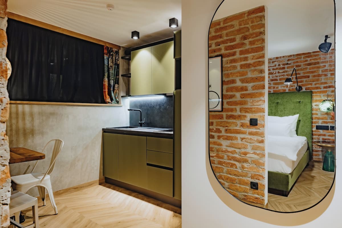 Cozinha compacta com pia, armários e área de refeições com uma cadeira e mesa.