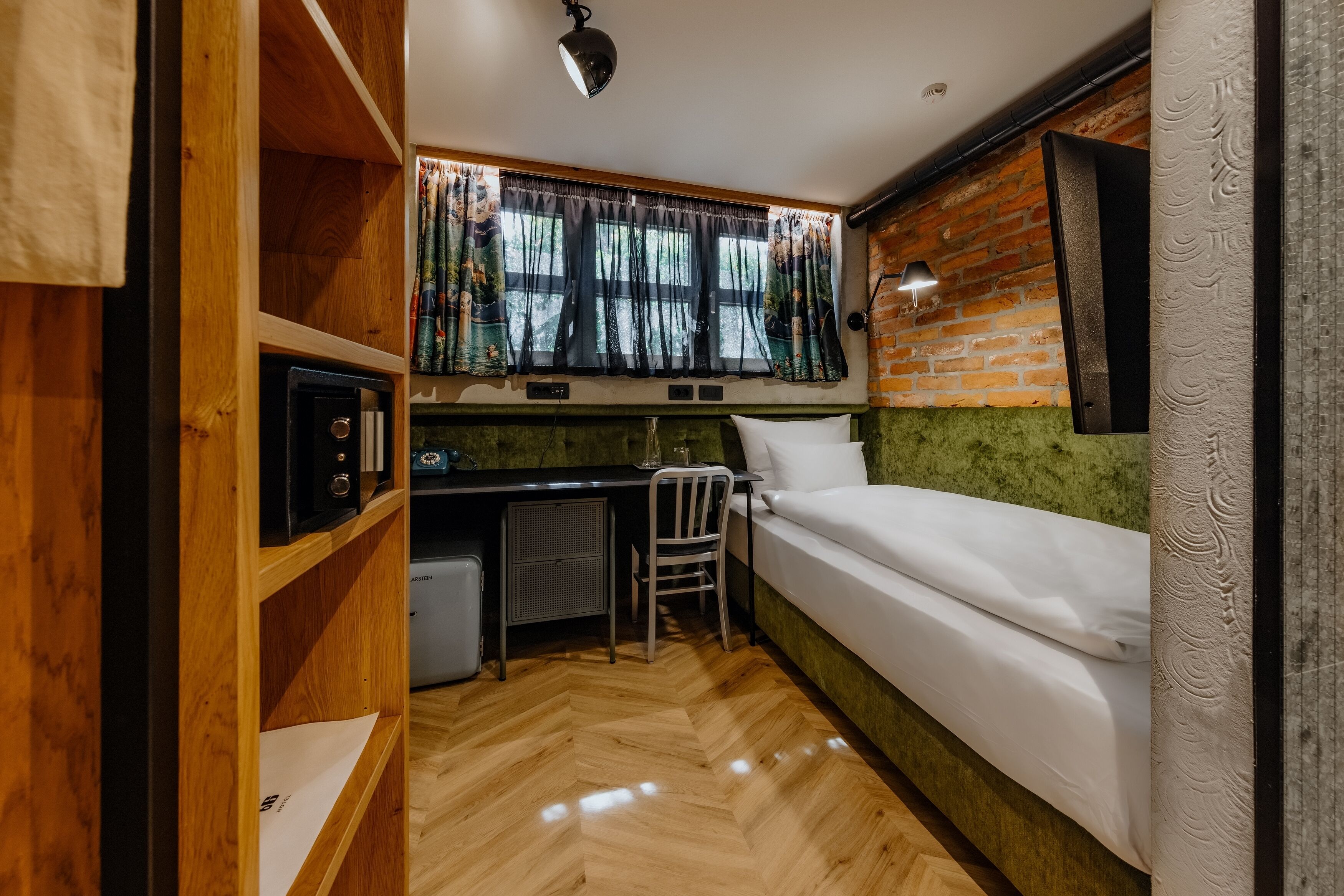 A compact room with a bed, a desk, and a chair.