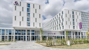En moderne hotelbygning med et tydeligt Premier Inn logo, store vinduer og et velholdt udendørs område med beplantning.