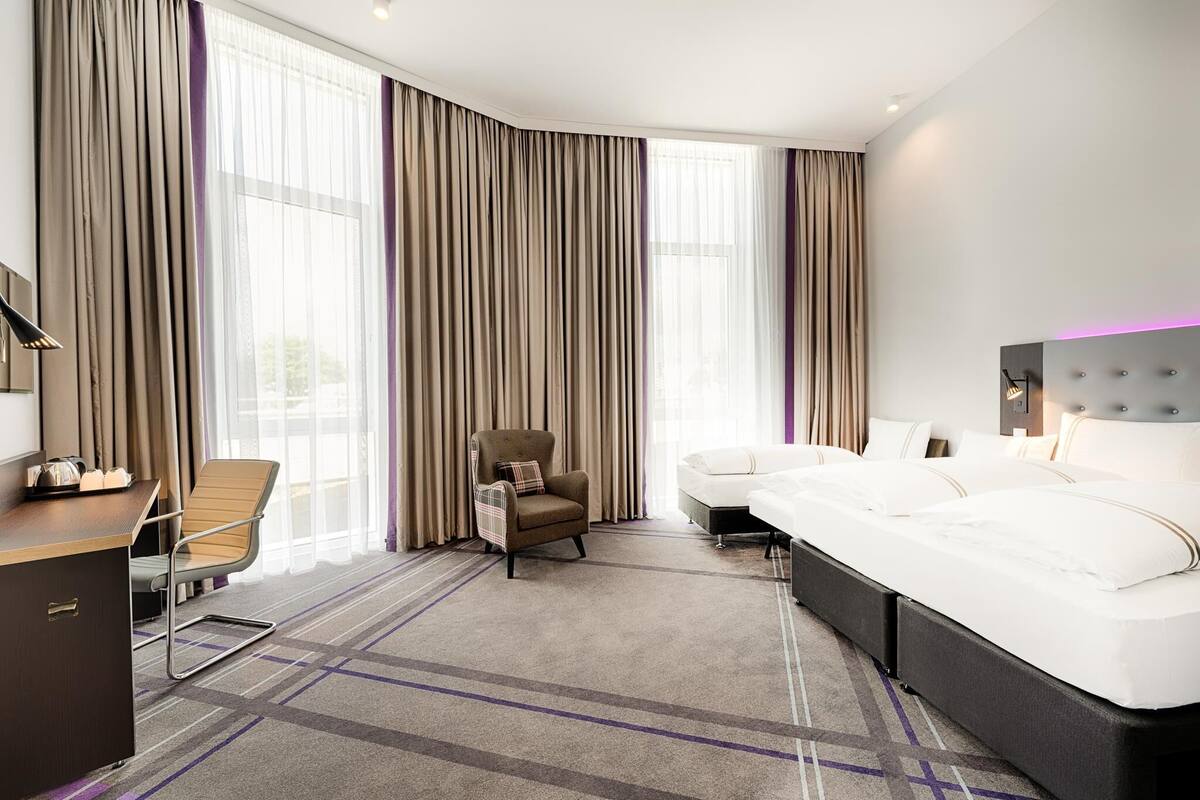 Ein Hotelzimmer mit Bett, Schreibtisch, Sessel und einer Couch.