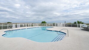 A swimming pool with a white fence and a clear view of the sky. - Upgraded Oceanfront 3BR Condo in WrightsvilleDunes (Wrightsville Beach)