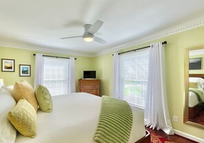 Relax in a spacious room with a large bed, ceiling fan, and flat-screen TV.