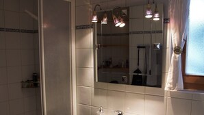 A bathroom with a shower, sink, toilet, and a mirror above the sink. - This stunning, bright and comfortable chalet can accommodate up to 8 people. Located on the Chemin d (Les Masses)