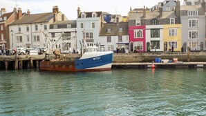A boat docked at a pier with colorful buildings in the background.