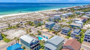 A coastal residential area with beachfront properties, a swimming pool, and a road leading to the beach.