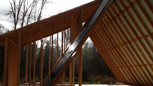 Una estructura de madera con techo inclinado, posiblemente un edificio en construcción o renovación.