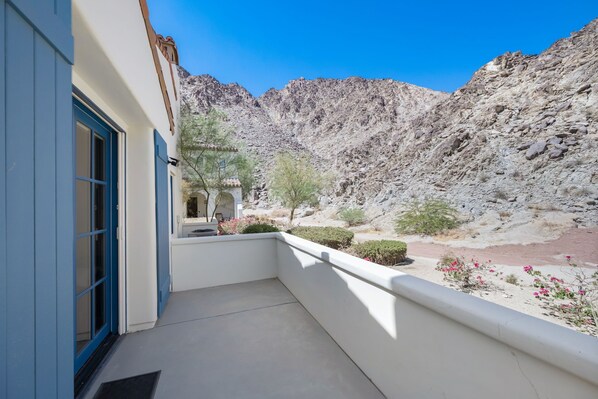A balcony with a view of a rocky mountain range.
