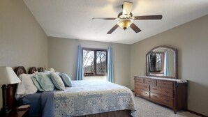 A bedroom with a bed, dresser, mirror, and ceiling fan. - Romantic Mountain house with views (Fairview)