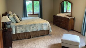 A bedroom with a bed, dresser, nightstand, and a ceiling fan. - Romantic Mountain house with views (Fairview)