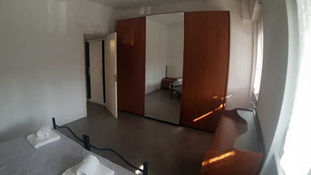 Ein Hotelzimmer mit einem Bett, einem großen Spiegel und einem Kleiderschrank.
