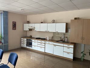 A modern kitchen with white cabinets, a built-in oven, and a sink.