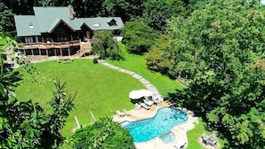 A large house with a swimming pool, surrounded by a well-maintained lawn and trees. - Vinewood Estate Luxury Pool and Vineyard Retreat (Hillsboro)