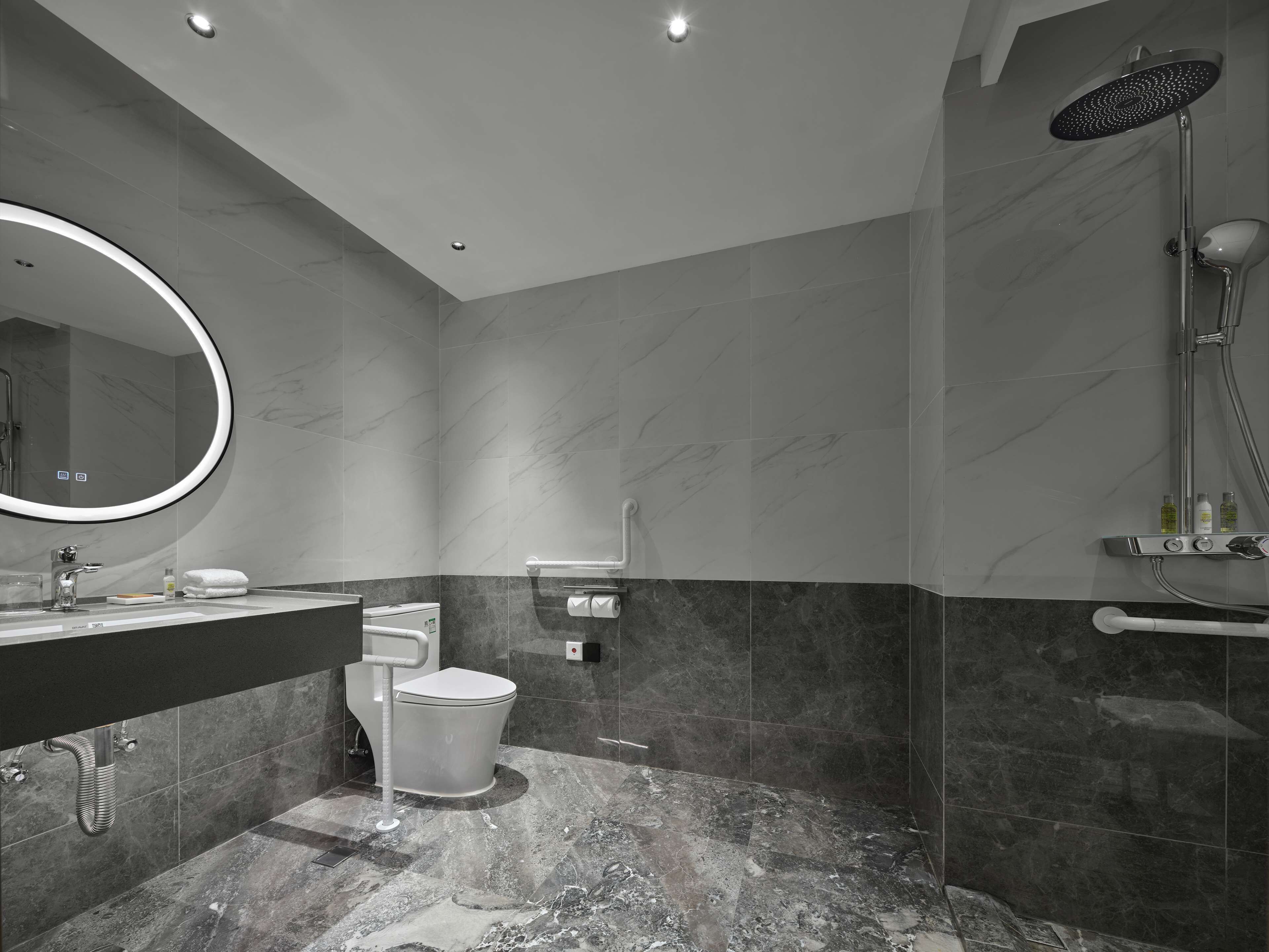 A modern bathroom with a toilet, sink, and shower.