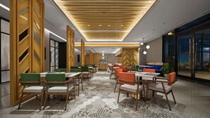 Un espace de restauration moderne, avec un lambris en bois, un revêtement de sol à motifs et différents types de sièges.