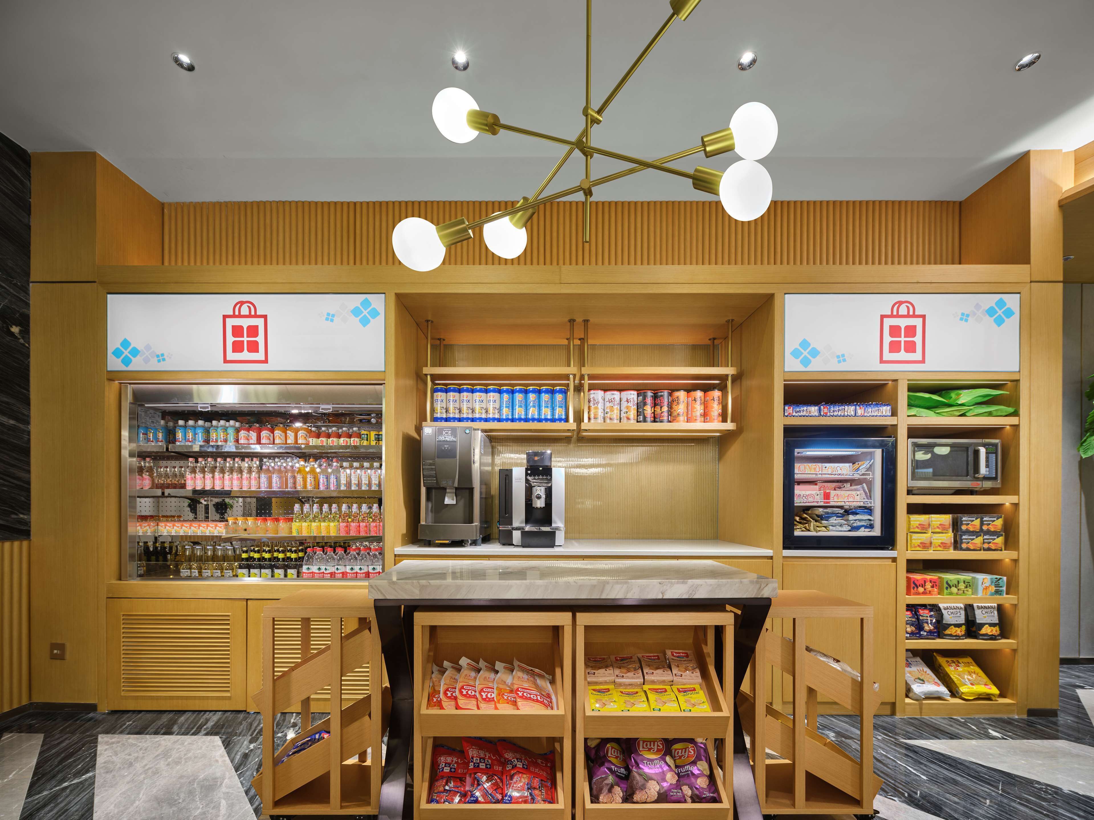 A self-service kiosk with refrigerated drinks, snacks, and a coffee machine.