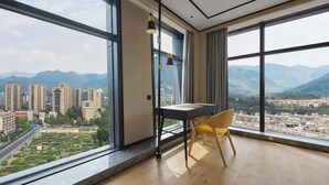 Une pièce moderne avec de grandes fenêtres, une table à manger et une chaise.