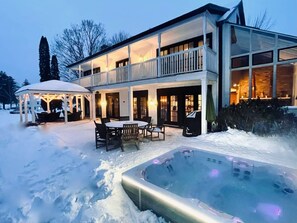 Un edificio de dos pisos con un porche cubierto y un jacuzzi al frente.