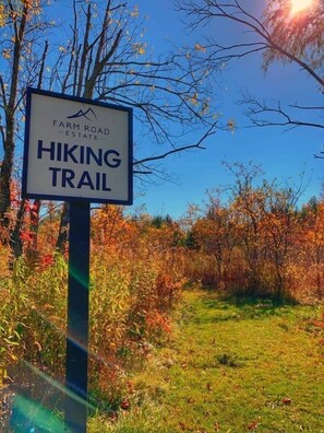 Un cartel de sendero con un logotipo y texto que indica que forma parte de Farm Road Estate.