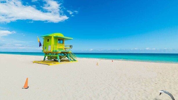 Una torre de salvavidas en una playa con cielo despejado.