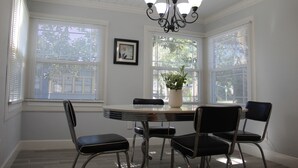 A dining area with a round table, four chairs, a chandelier, and a potted plant. - The Oasis in Murray Hill - Centrally Located- sleeps 8-  WiFi-Cozy-Free Parking (Jacksonville)