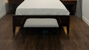 A neatly made bed with a wooden headboard, two bedside tables with lamps, and a bench at the foot of the bed. - The Oasis in Murray Hill - Centrally Located- sleeps 8-  WiFi-Cozy-Free Parking (Jacksonville)
