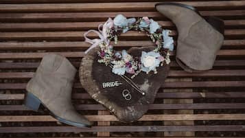 A wooden bench with a heart-shaped object on it, labeled 'BRIDE,' and a pair of boots.