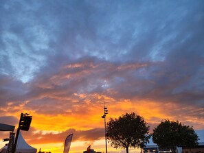 Atardecer con nubes, una tienda de campaña y árboles.