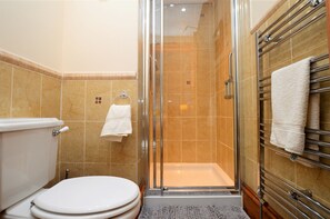A bathroom with a glass-enclosed shower, a toilet, and a towel rack with towels. - Arthur's Seat,  elevated cottage, sea views (Dunoon)