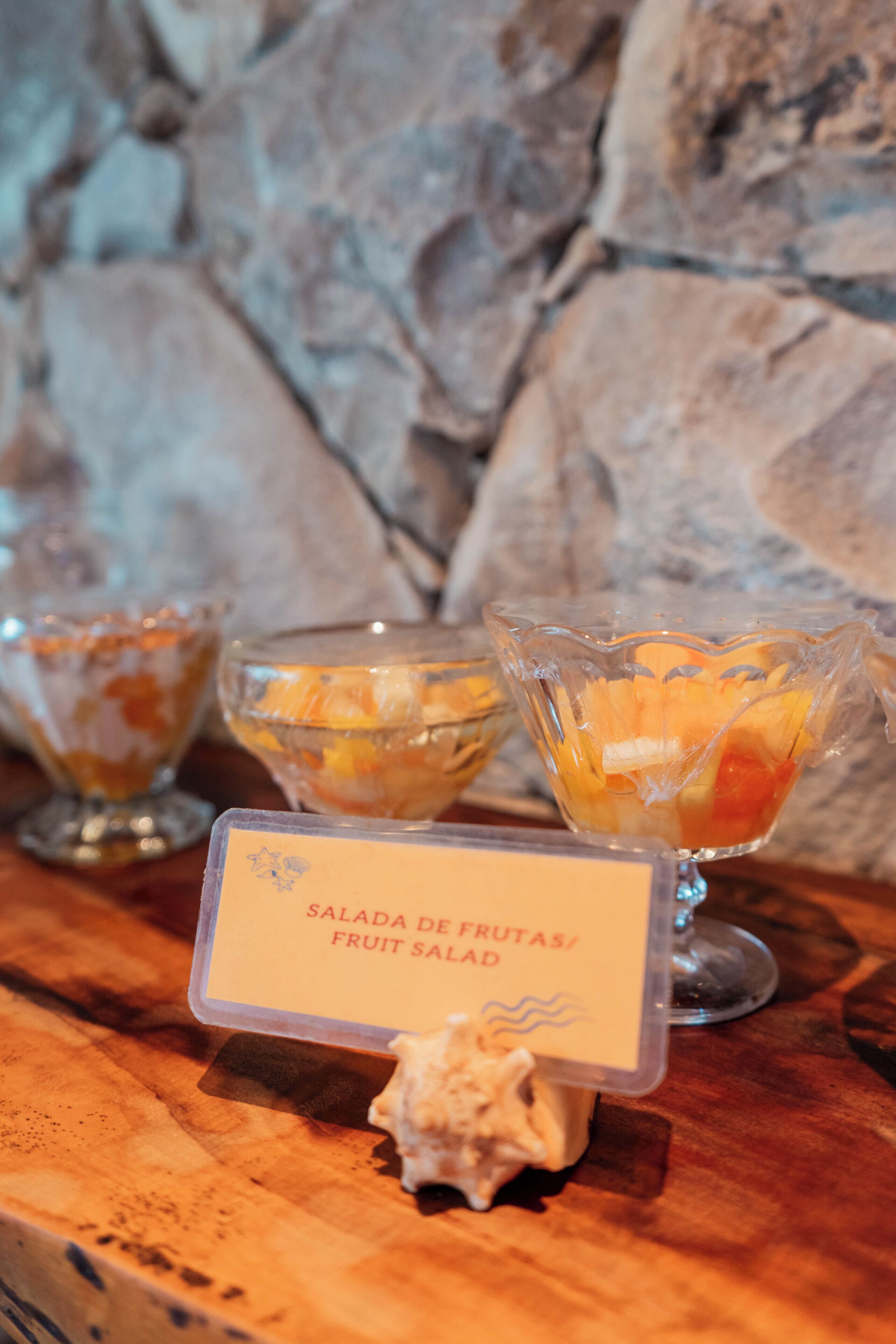 A fruit salad display with a sign indicating it is a fruit salad.