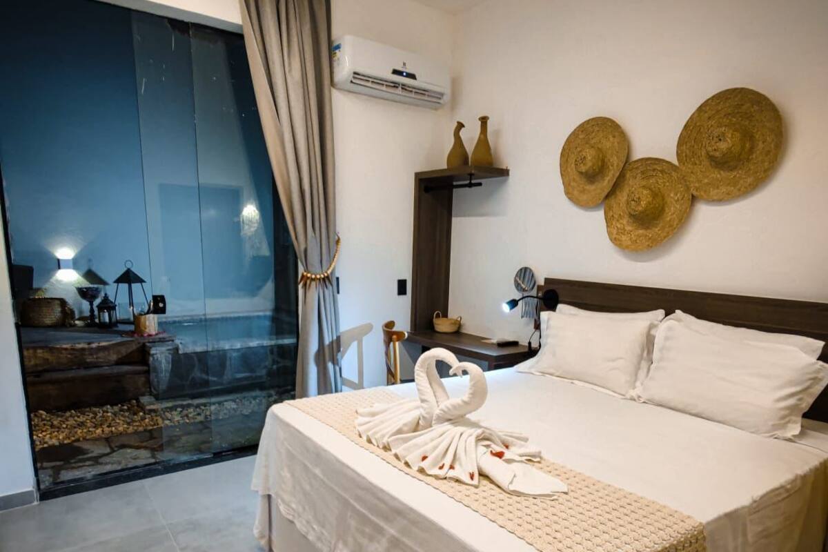 Een moderne hotelkamer met een groot bed, een balkon met uitzicht en decoratieve muurkunst.