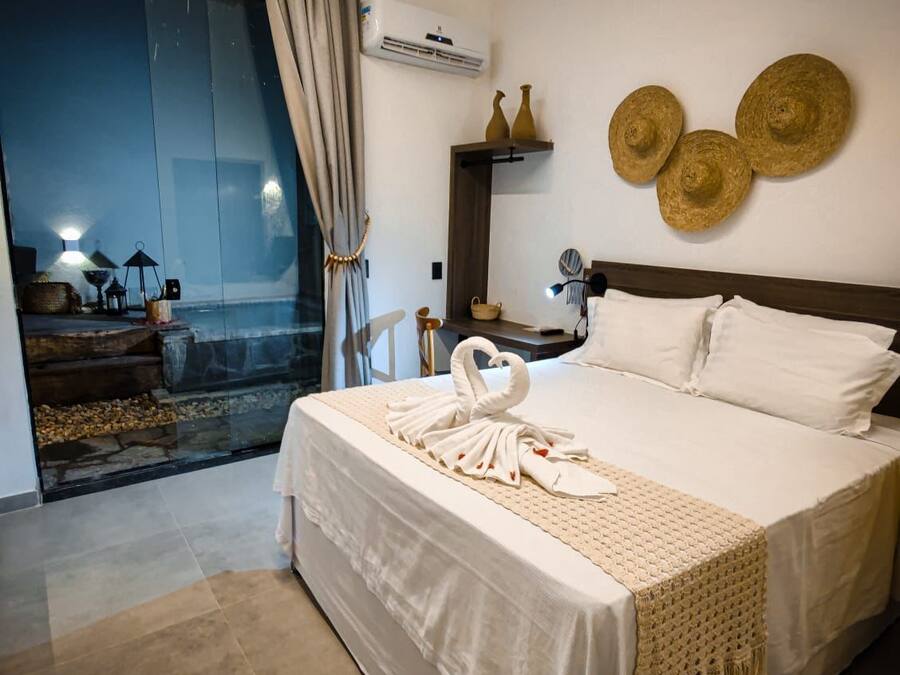 A modern hotel room with a large bed, a balcony with a view, and decorative wall art.