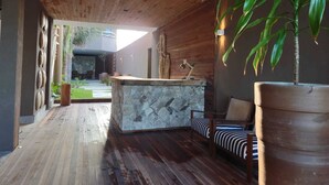 Un interior moderno con encimera de piedra, suelo de madera y una planta grande en maceta.